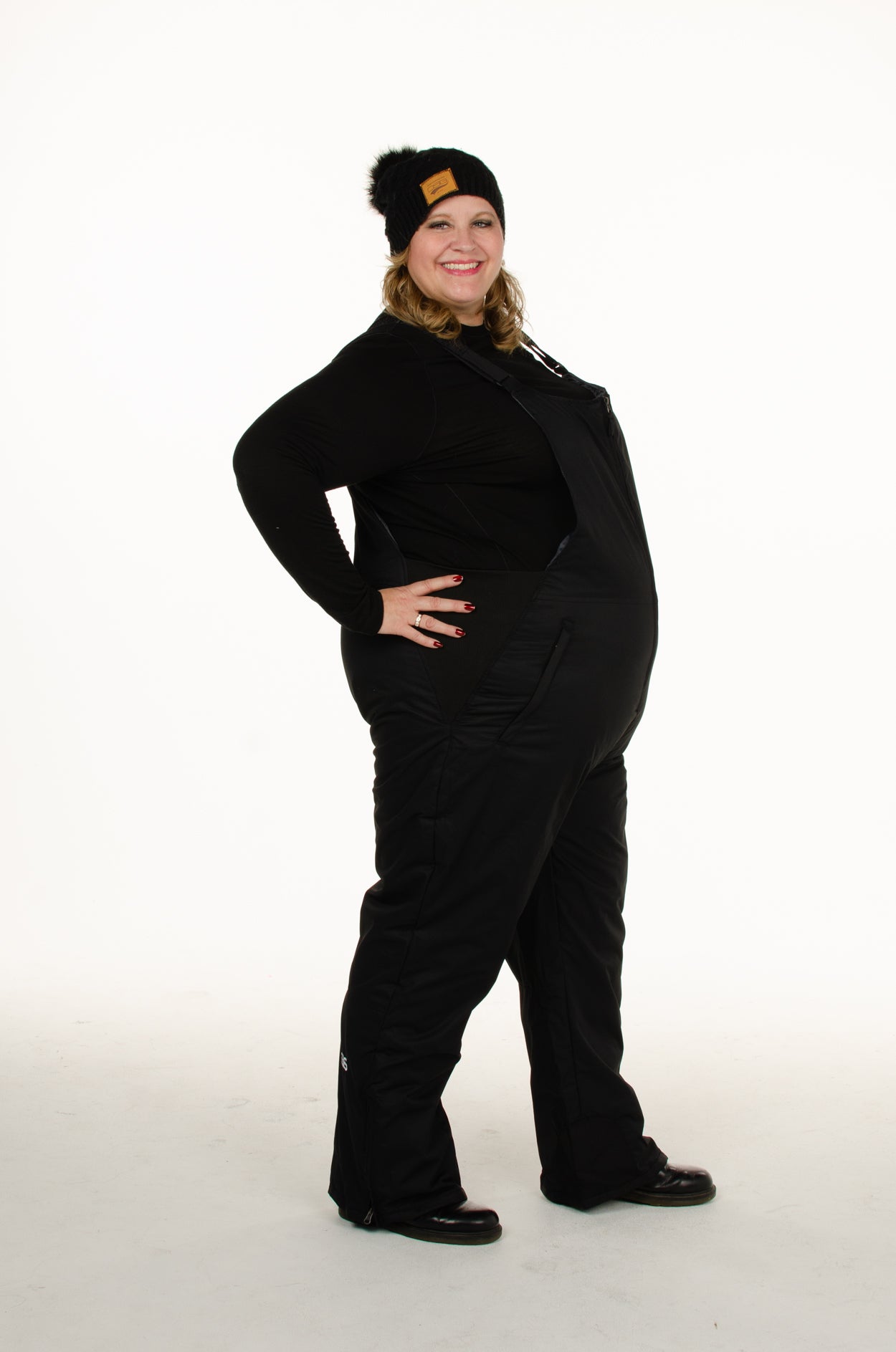 Plus size woman right view of  Arctix black snow bibs