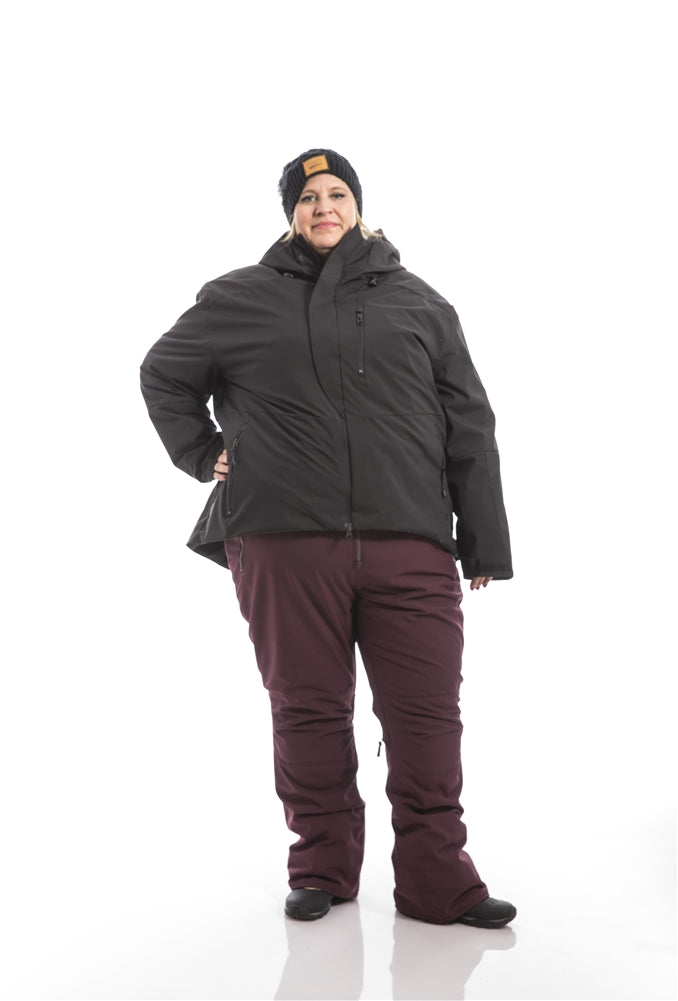 Kindra wearing a Swiss System 3 in one jacket over Groove Bibs zipped hands on hip