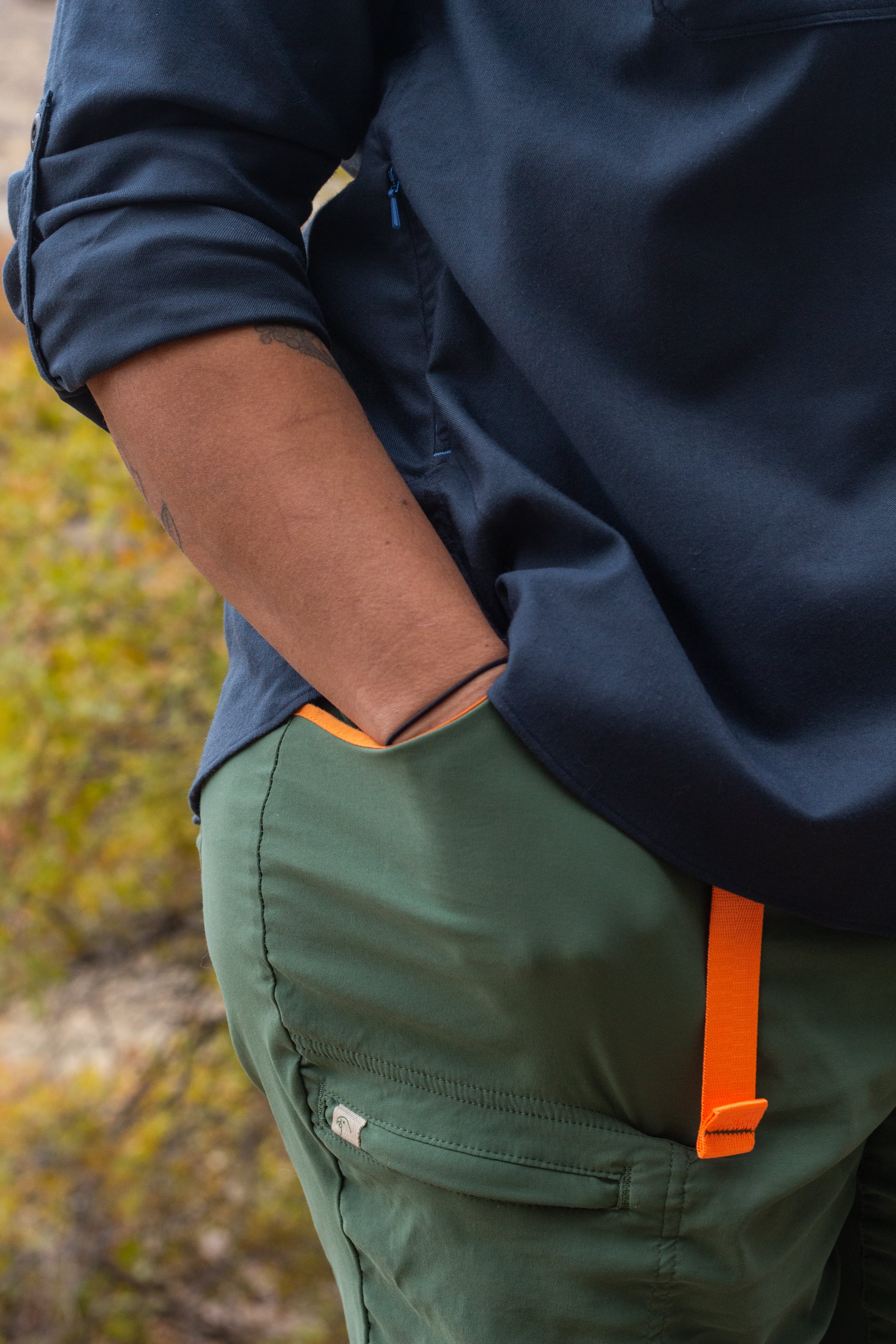 Close up of a hand in pocket of 360 image of DeeAnn wearing Alpine Parrot Ponderosa Pants in sage green