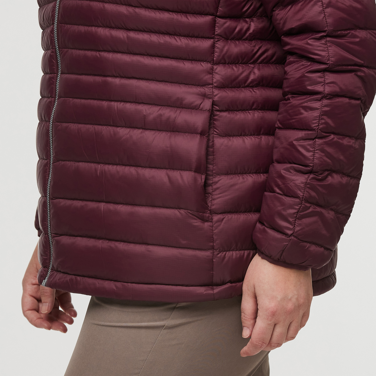 View of sleeve of woman wearing Cotopaxi Fuego Down Plus Size Hooded Jacket in Wine Stripes