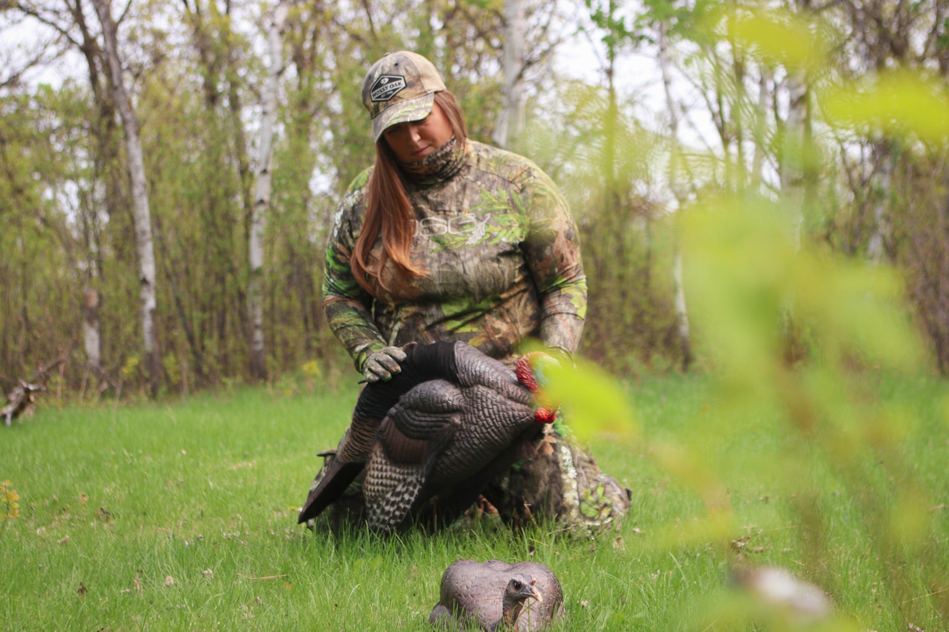Plus size woman setting up turkey decoys, wearing DSG outerwear camo. 