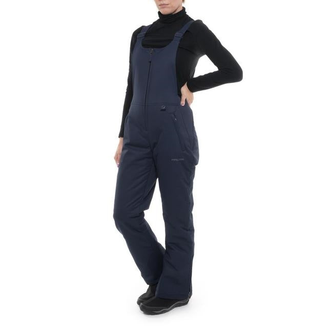Woman wearing blue night Arctix snow bibs with hands on hips